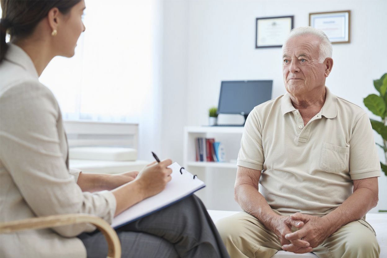 Пожилая женщина с болезнью Паркинсона пьет чай